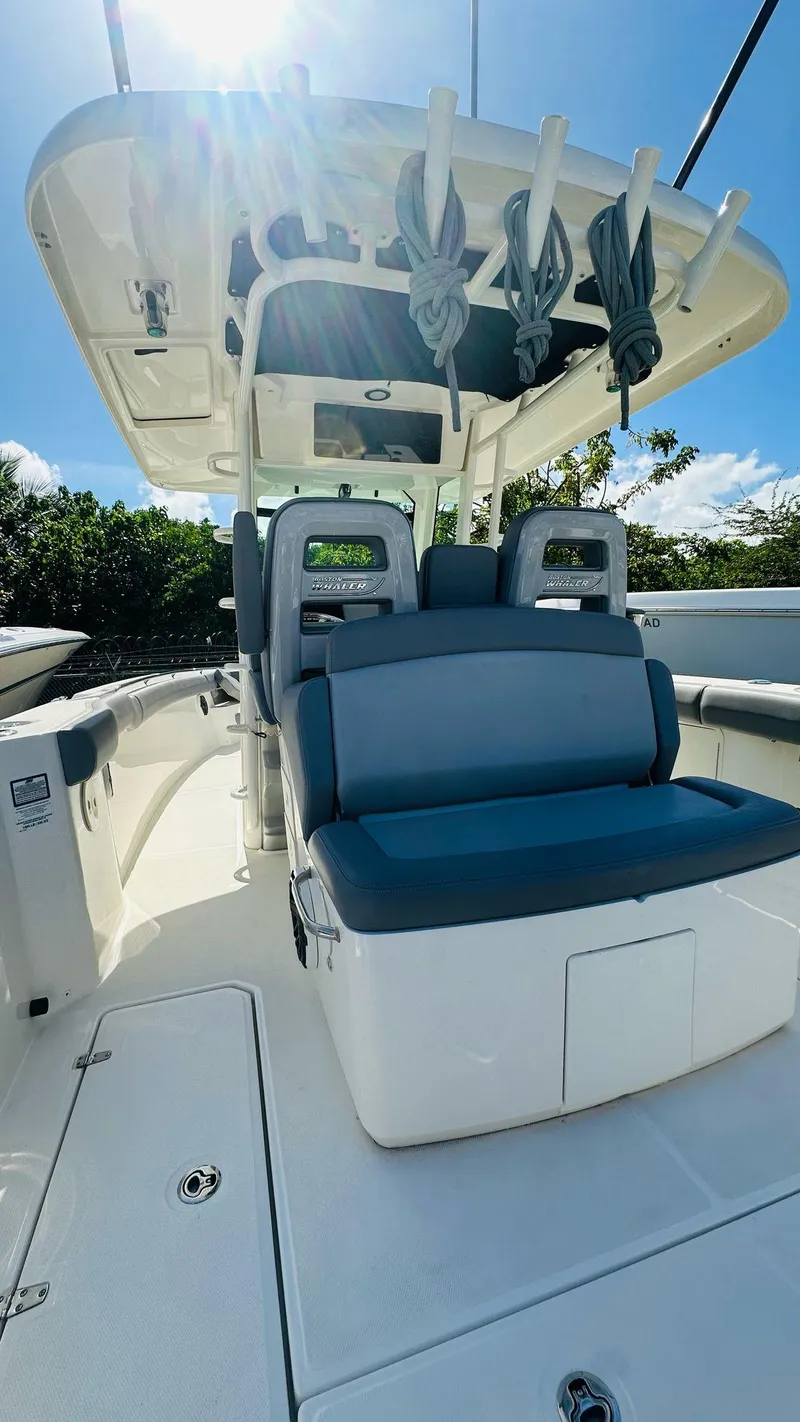 Slide: The Image of 2023 Boston Whaler 330 Outrage boat interior with seating and overhead storage. - 15