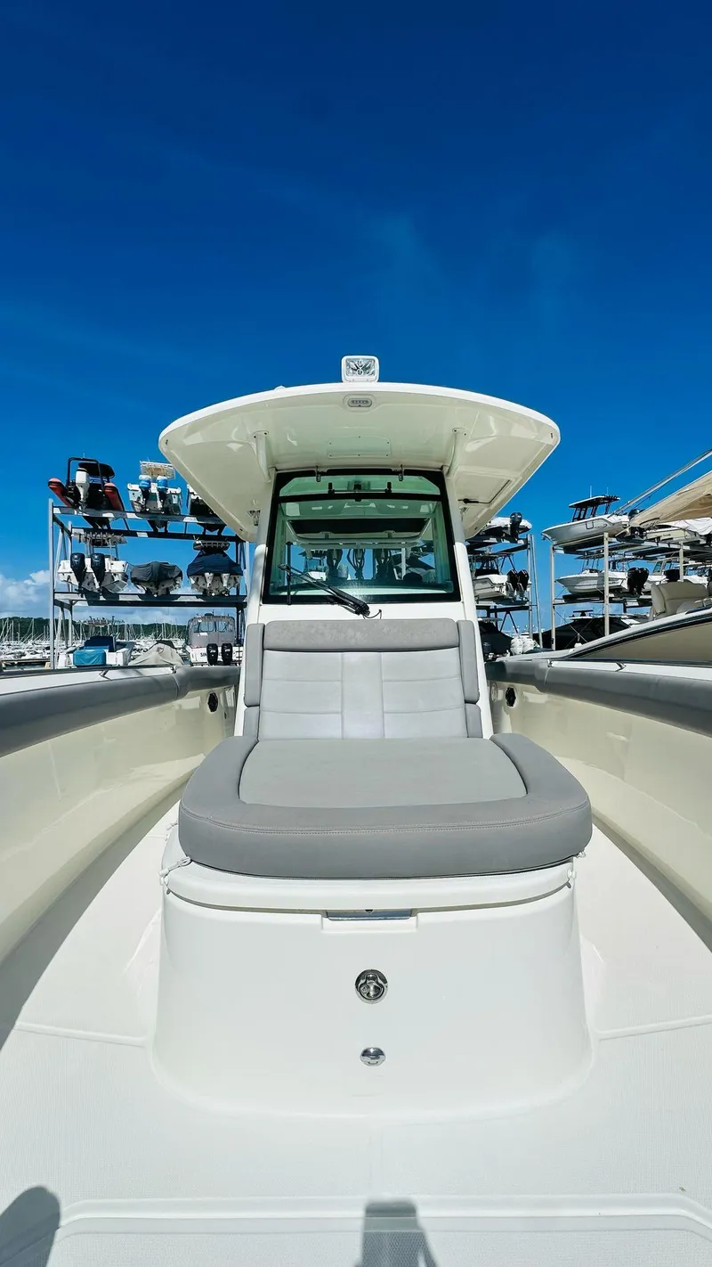 Slide: The Image of 2023 Boston Whaler 330 Outrage boat with sleek design under clear blue sky. - 23