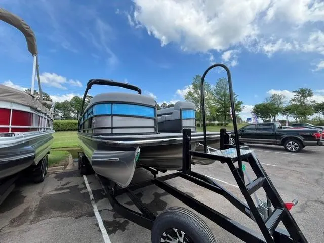 Slide: The Image of 2025 Veranda Relax VR22RC pontoon boat on trailer under a clear blue sky. - 3