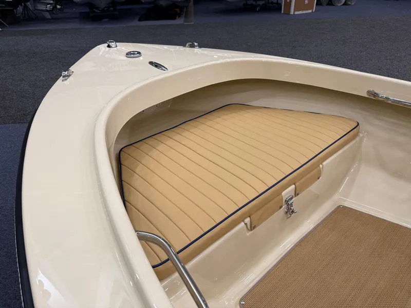 Slide: The Image of 2025 Rossiter 14 boat interior with beige cushioned seating and carpeted flooring. - 11