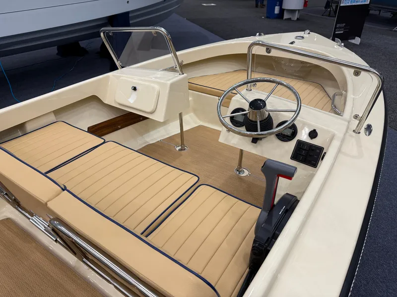 Slide: The Image of 2025 Rossiter 14 boat interior with tan seating and steering wheel. - 16