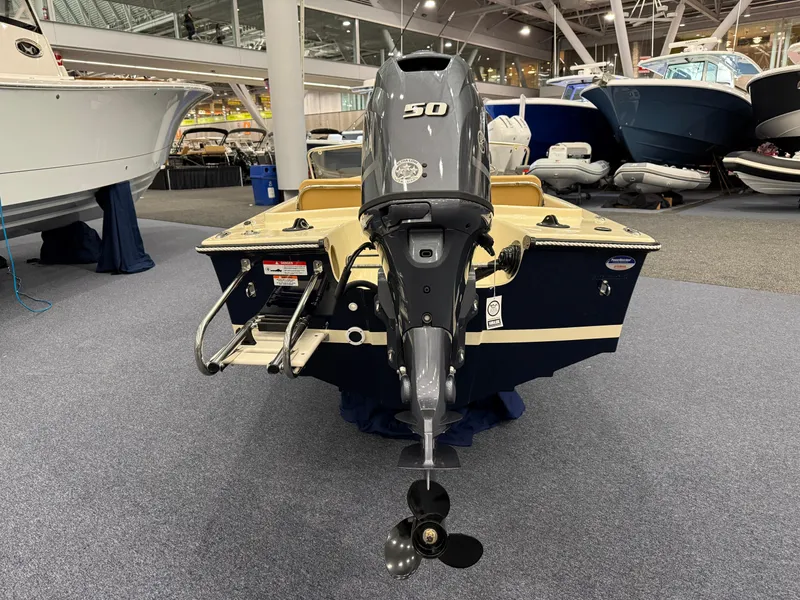 Slide: The Image of 2025 Rossiter 14 boat with 50 HP outboard motor displayed indoors. - 4