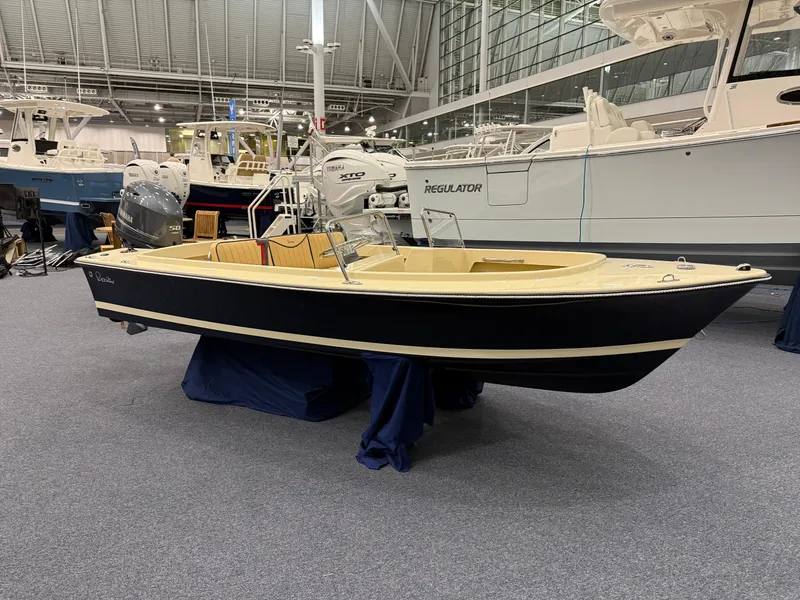 Slide: The Image of 2025 Rossiter 14 boat displayed indoors at a boat show. - 7