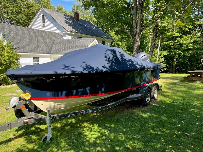 Slide: The Image of 2018 Rossiter 20 Coastal Cruiser boat covered on trailer, parked on grass near house. - 11