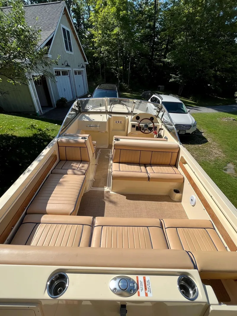Slide: The Image of 2018 Rossiter 20 Coastal Cruiser with tan seating, parked near a house and cars. - 2