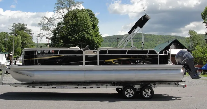 Slide: The Image of 2012 Veranda RFL2575V pontoon boat on trailer, parked outdoors. - 1