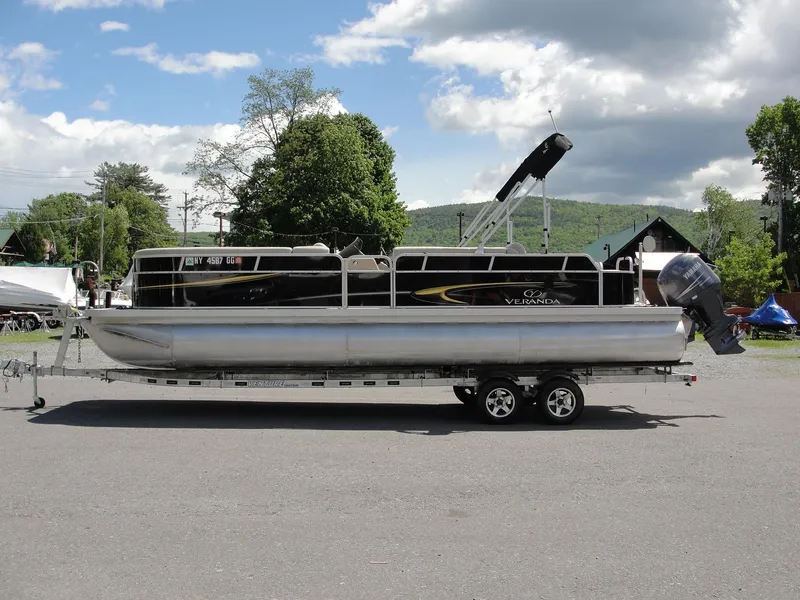 Slide: The Image of 2012 Veranda RFL2575V pontoon boat on trailer, parked outdoors. - 2
