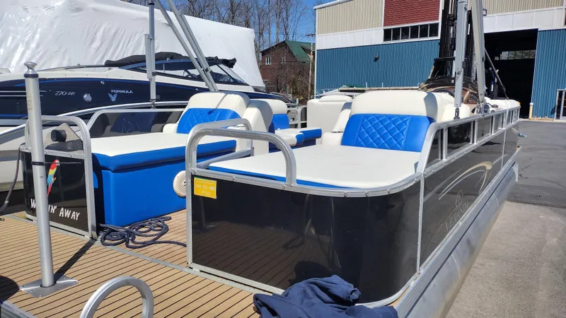 Slide: The Image of 2012 Veranda RFL2575V pontoon boat with blue and white seating, docked near a warehouse. - 29