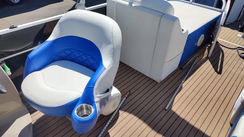 Slide: The Image of 2012 Veranda RFL2575V boat interior with blue and white seating on a wooden deck. - 32