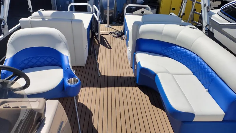 Slide: The Image of Luxurious 2012 Veranda RFL2575V pontoon boat with blue and white seating on a wooden deck. - 35