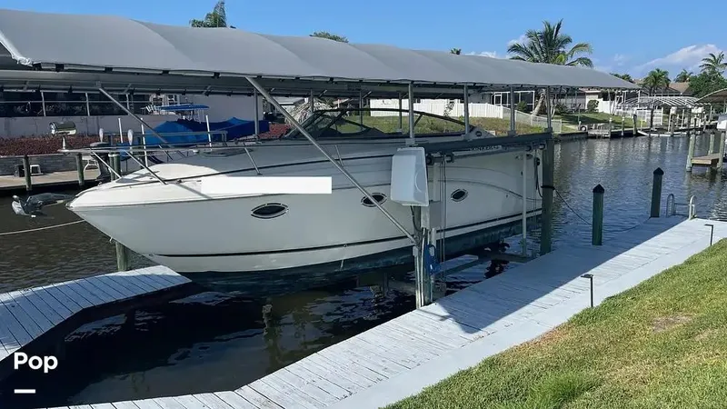 The Image of 2007 Rinker 280 boat docked under a canopy on a sunny day. - 0