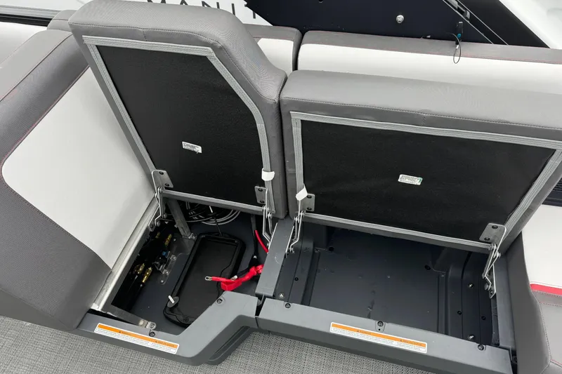 Slide: The Image of 2025 Manitou 22' Cruise Switchback boat storage compartments open, showcasing interior space. - 7