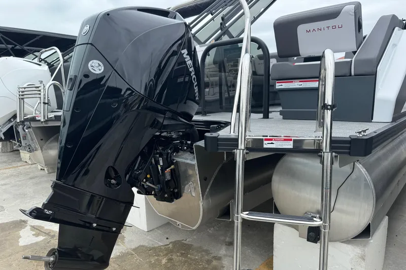 Slide: The Image of 2025 Manitou 22' Cruise Switchback with Mercury outboard motor and sleek design. - 9