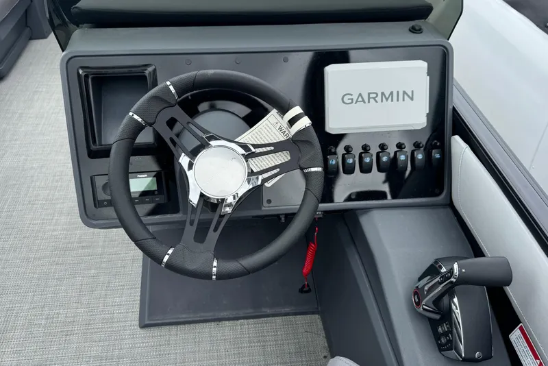 Slide: The Image of 2025 Manitou 22' Cruise Switchback dashboard with Garmin navigation and modern steering wheel. - 7