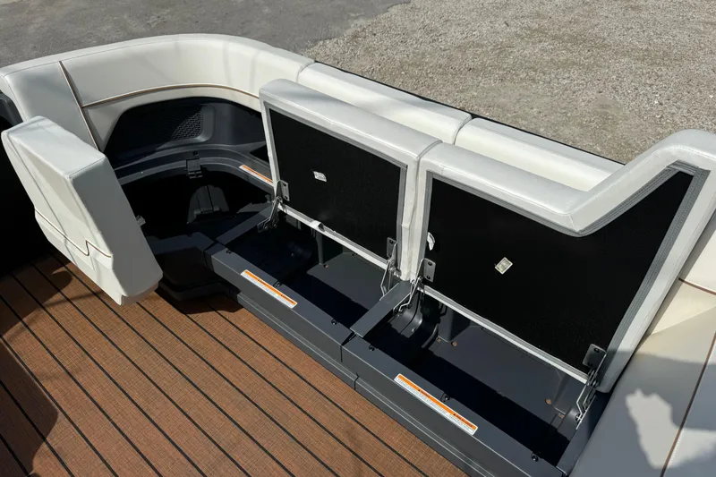 Slide: The Image of 2025 Manitou 24' Explore Switchback boat interior with open storage compartments. - 4