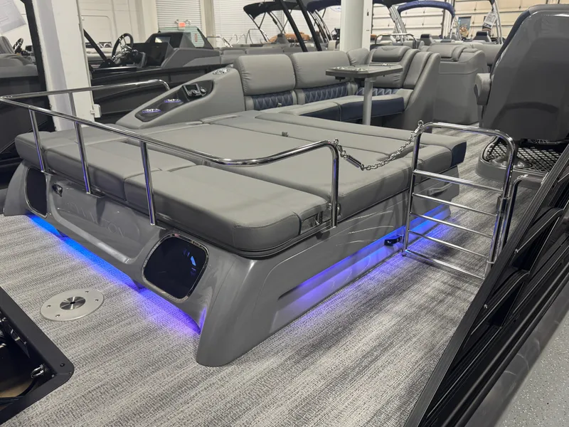Slide: The Image of 2025 Bennington 25 RSB boat interior with gray seating and blue LED lighting. - 19