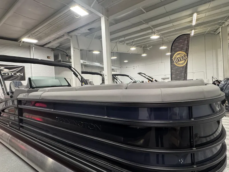 Slide: The Image of 2025 Bennington 25 RSB pontoon boat in showroom, sleek design, modern interior. - 2