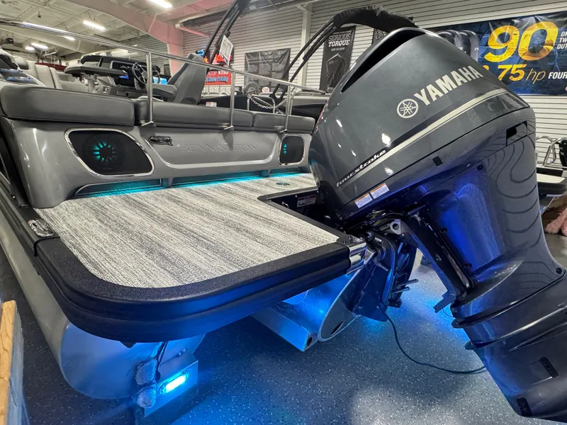 Slide: The Image of 2025 Bennington 25 RSB boat with Yamaha outboard motor, illuminated deck, indoor showroom. - 25