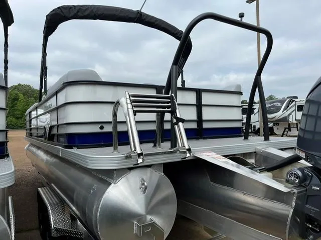 Slide: The Image of 2025 Veranda Vista Sport 25RC pontoon boat, rear view with ladder and canopy, parked outdoors. - 7