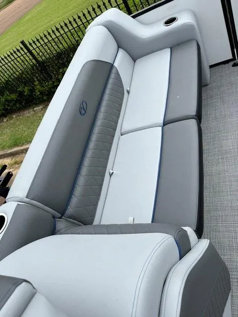 Slide: The Image of 2025 Veranda Vista Sport 25RC boat interior with gray and white seating, cup holders, and sleek design. - 9