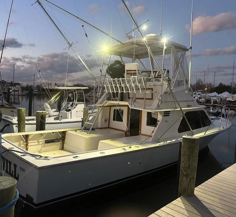 Slide: The Image of 1986 Blackfin 32 Flybridge boat docked at sunset with lights on. - 1