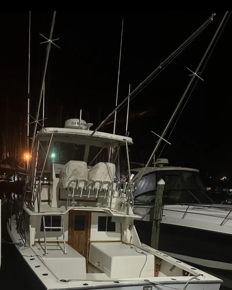 Slide: The Image of 1986 Blackfin 32 Flybridge boat docked at night with fishing rods. - 2