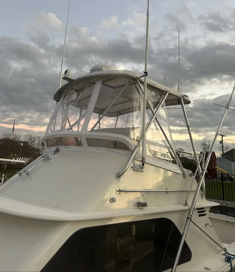 Slide: The Image of 1986 Blackfin 32 Flybridge boat with enclosed flybridge, set against a cloudy sky. - 5