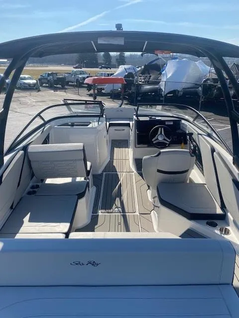 Slide: The Image of 2025 Sea Ray SPX 210 boat interior with seating and steering wheel, docked outdoors. - 3