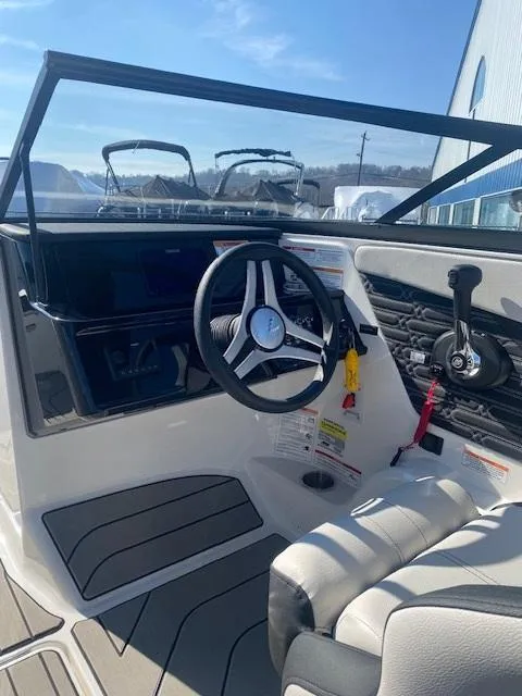 Slide: The Image of 2025 Sea Ray SPX 210 boat interior with steering wheel and dashboard controls. - 4