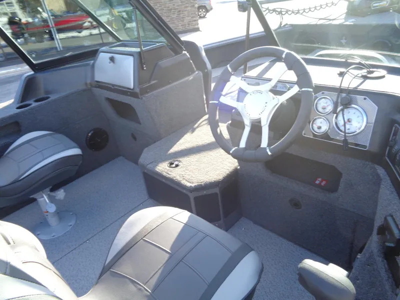 Slide: The Image of 2025 Lund 1875 Impact XS Sport boat interior with steering wheel and seating. - 13