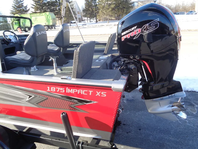 Slide: The Image of 2025 Lund 1875 Impact XS Sport boat with Mercury Pro XS engine, parked outdoors. - 5