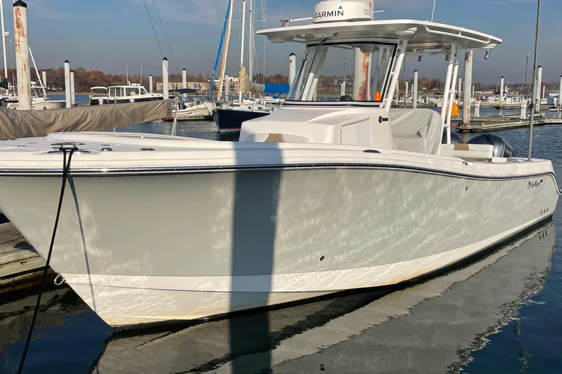Slide: The Image of 2015 Edgewater 280CC boat docked in a marina under clear skies. - 1
