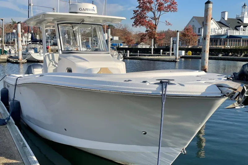Slide: The Image of 2015 Edgewater 280CC boat docked in a marina with autumn trees. - 2