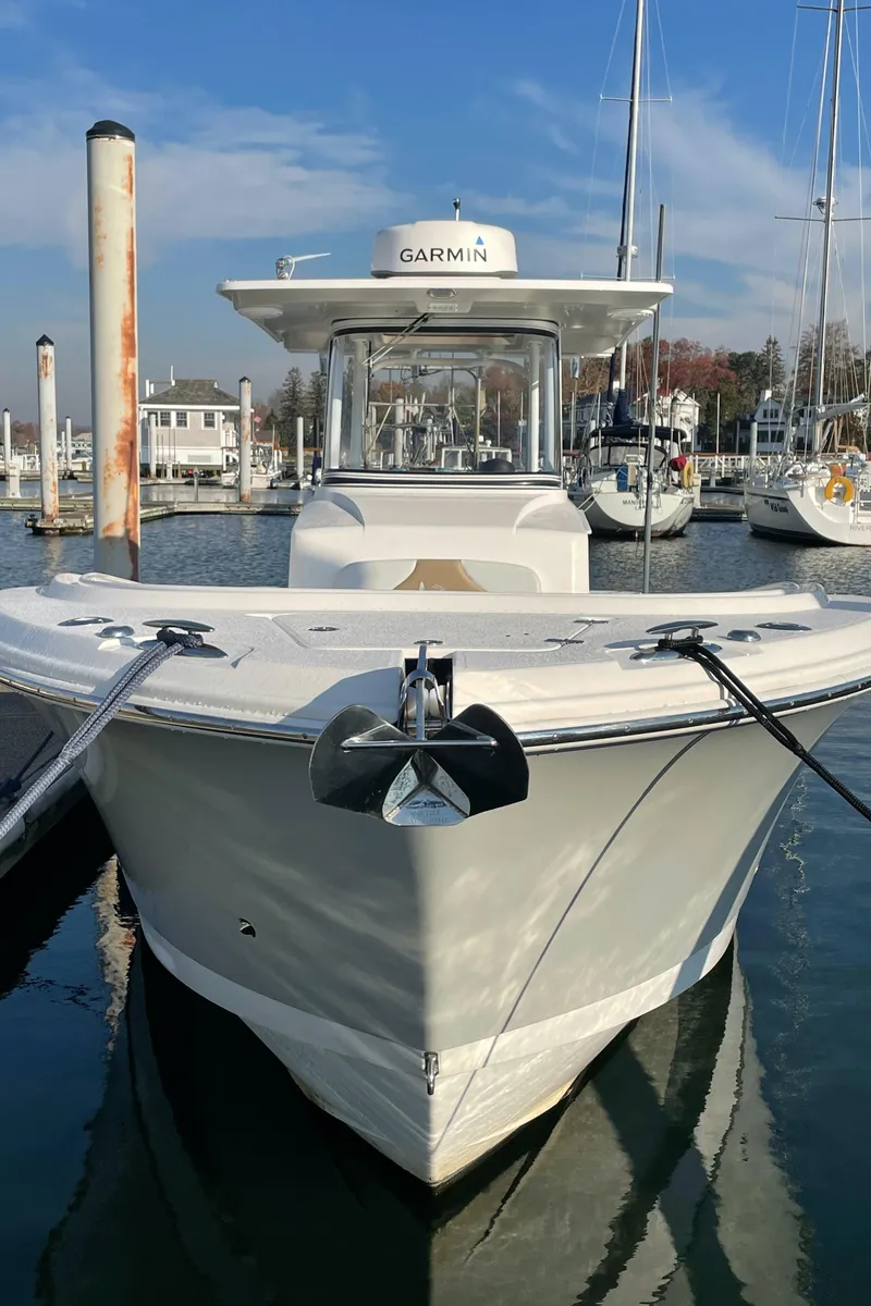 Slide: The Image of 2015 Edgewater 280CC boat docked in marina, featuring Garmin equipment. - 3