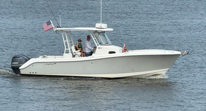 Slide: The Image of 2015 Edgewater 280CC boat cruising on water with passengers and American flag. - 5