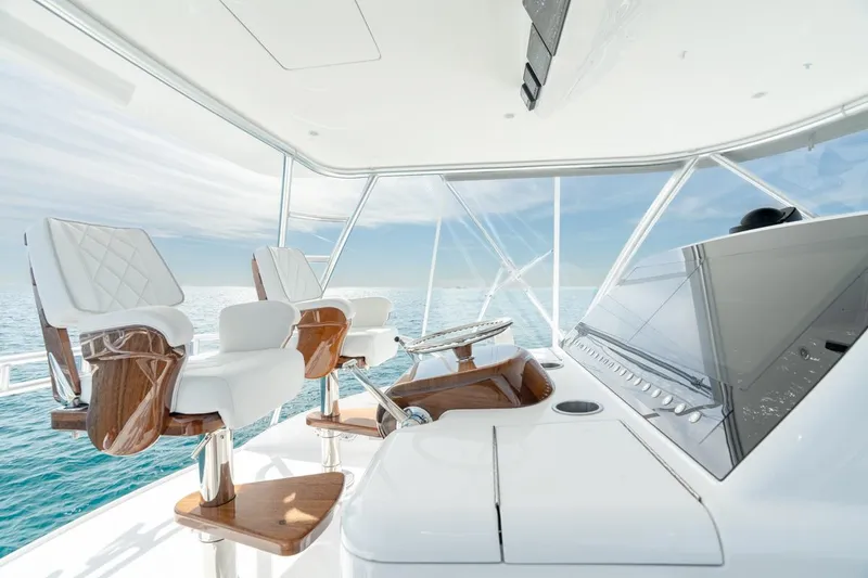 Slide: The Image of 2025 Viking 54 Convertible yacht helm with luxurious seating and ocean view. - 13