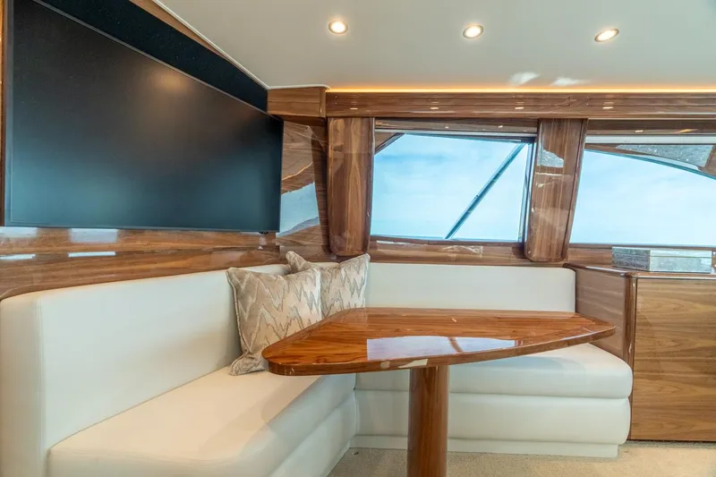 Slide: The Image of Luxurious interior of 2025 Viking 54 Convertible yacht with elegant seating and wooden table. - 21