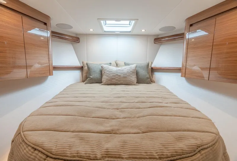 Slide: The Image of Luxurious bedroom interior of 2025 Viking 54 Convertible yacht with elegant wood finishes. - 24