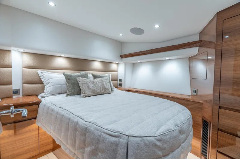 Slide: The Image of Luxurious bedroom interior of 2025 Viking 54 Convertible yacht, featuring elegant wood finishes. - 25