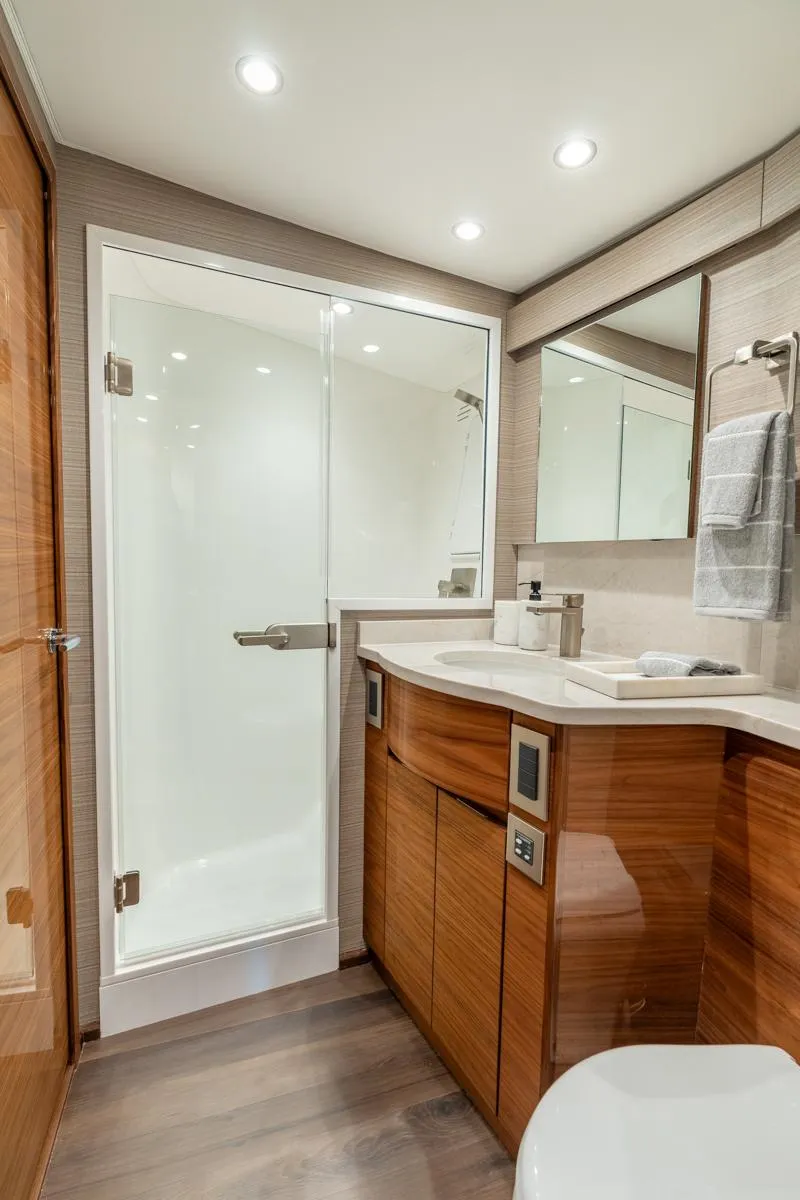Slide: The Image of Luxurious bathroom in 2025 Viking 54 Convertible yacht with modern fixtures and elegant wood cabinetry. - 28