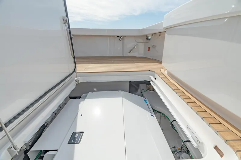 Slide: The Image of 2025 Viking 54 Convertible yacht engine compartment with open hatch and teak deck. - 4