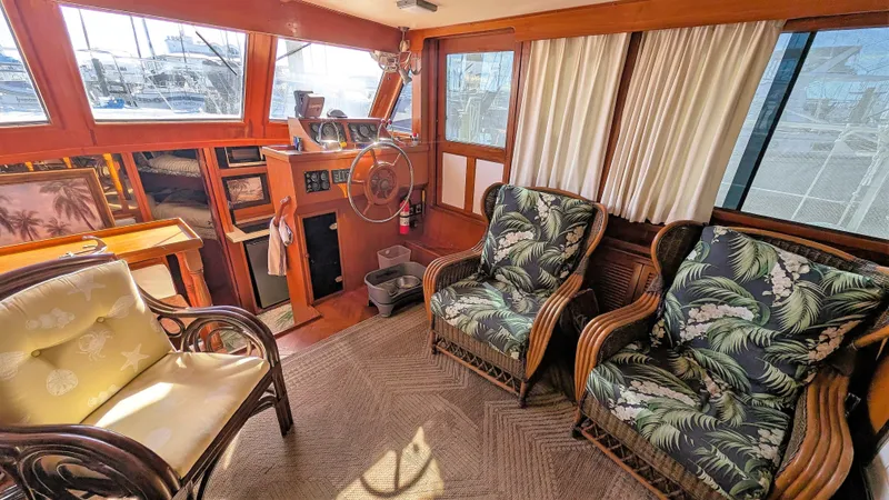 Slide: The Image of Interior of 1986 Heritage East 40 Sundeck with tropical-themed seating and wooden helm. - 12