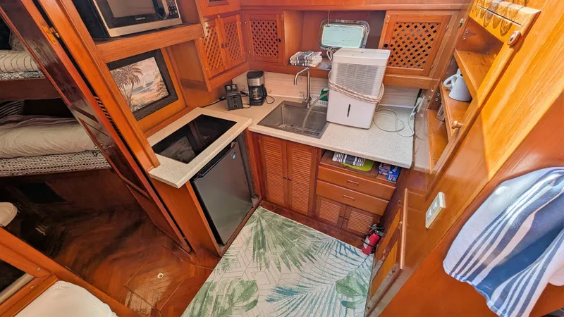 Slide: The Image of Compact kitchen area in 1986 Heritage East 40 Sundeck yacht with wooden cabinetry. - 18