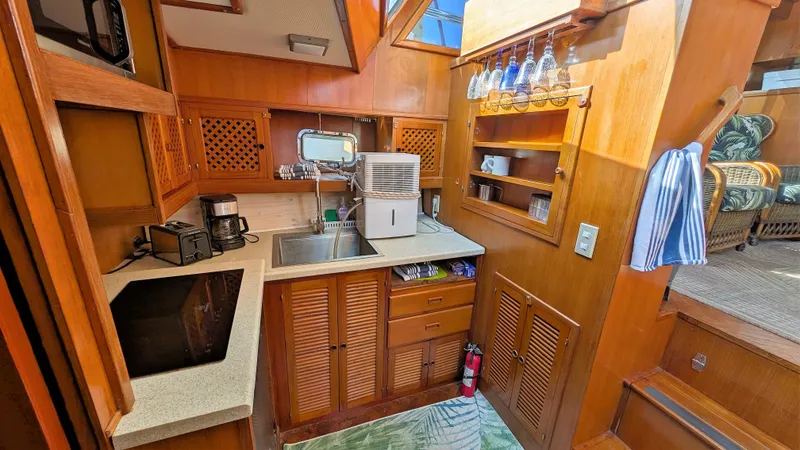 Slide: The Image of 1986 Heritage East 40 Sundeck yacht kitchen with wooden cabinetry and modern appliances. - 20