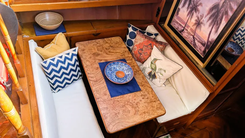 Slide: The Image of Cozy dining area in 1986 Heritage East 40 Sundeck with decorative pillows and wooden table. - 22