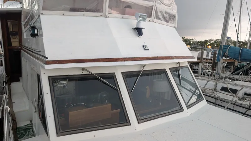 Slide: The Image of 1986 Heritage East 40 Sundeck boat docked at marina, showcasing cabin and windows. - 3