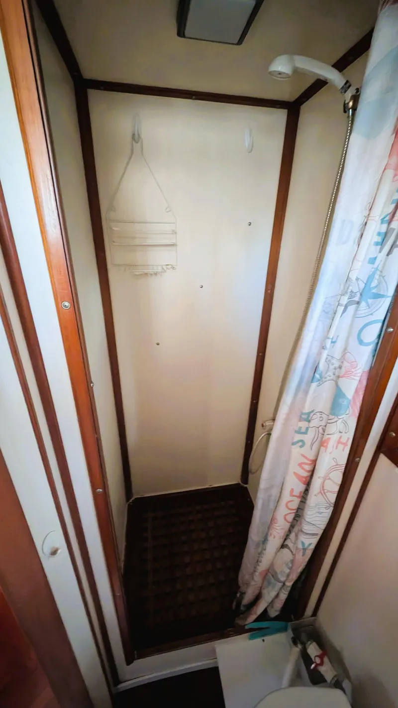 Slide: The Image of 1986 Heritage East 40 Sundeck shower area with curtain and wooden accents. - 36