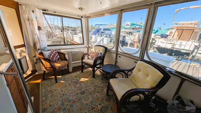 Slide: The Image of 1986 Heritage East 40 Sundeck interior with cozy seating and marina view. - 40