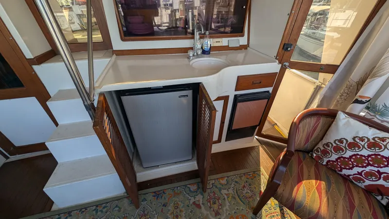 Slide: The Image of 1986 Heritage East 40 Sundeck interior with kitchenette, mini fridge, and seating area. - 42