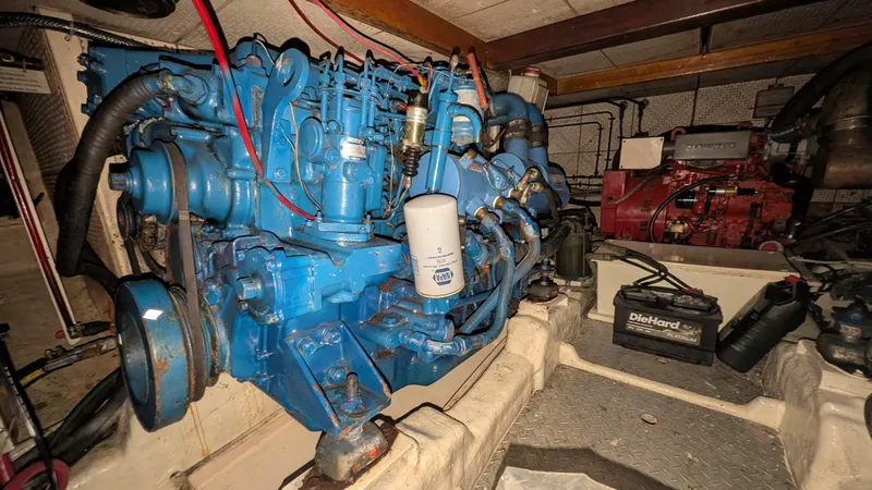 Slide: The Image of Engine room of 1986 Heritage East 40 Sundeck with blue engine and DieHard battery. - 53